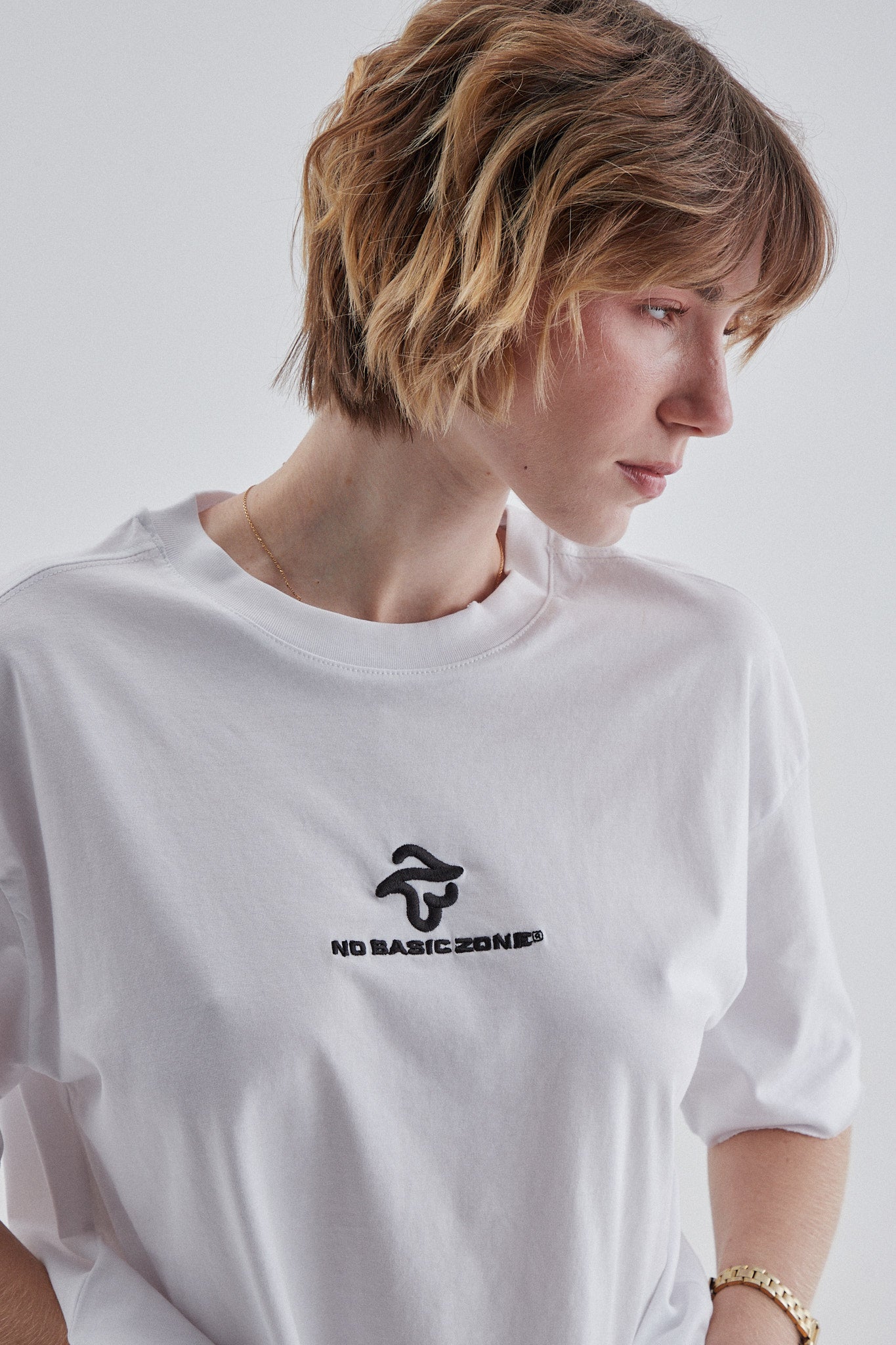 Camiseta blanca de la marca No Basic Zone con diseño de anillos, vista frontal sobre fondo neutro