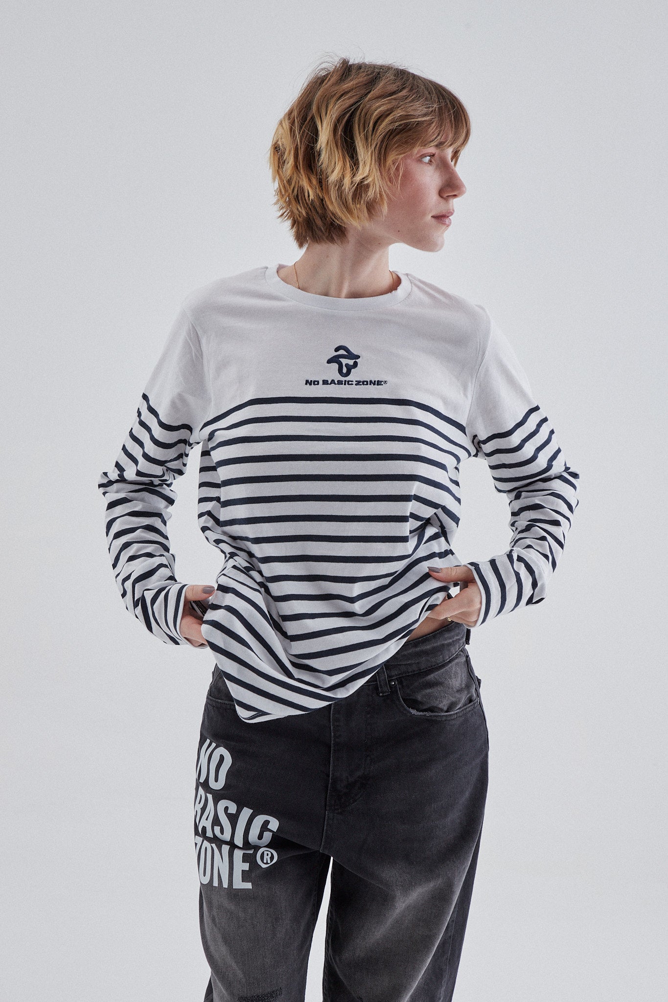 Camiseta larga con rayas en azul marino y blanco de la marca No Basic Zone, con diseño estirado y detalles visibles.