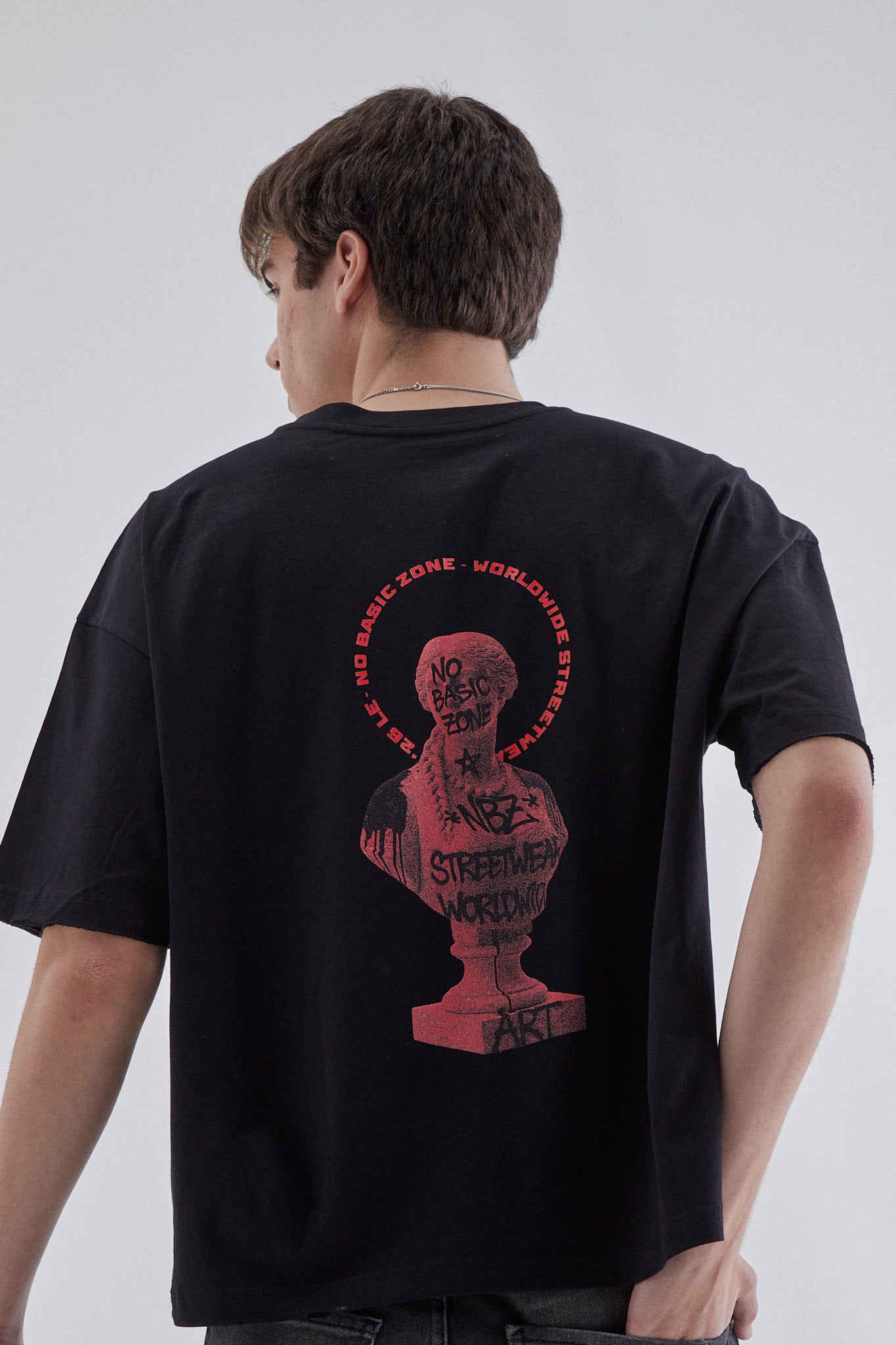 Camiseta negra de la marca No Basic Zone con diseño de estatua, vista frontal sobre fondo blanco.